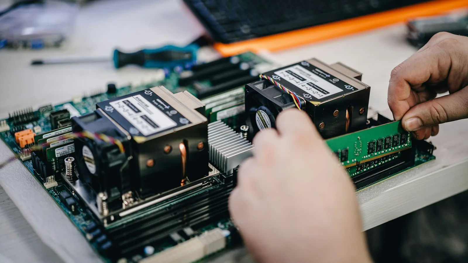 Mano instalando un módulo de RAM en una placa madre